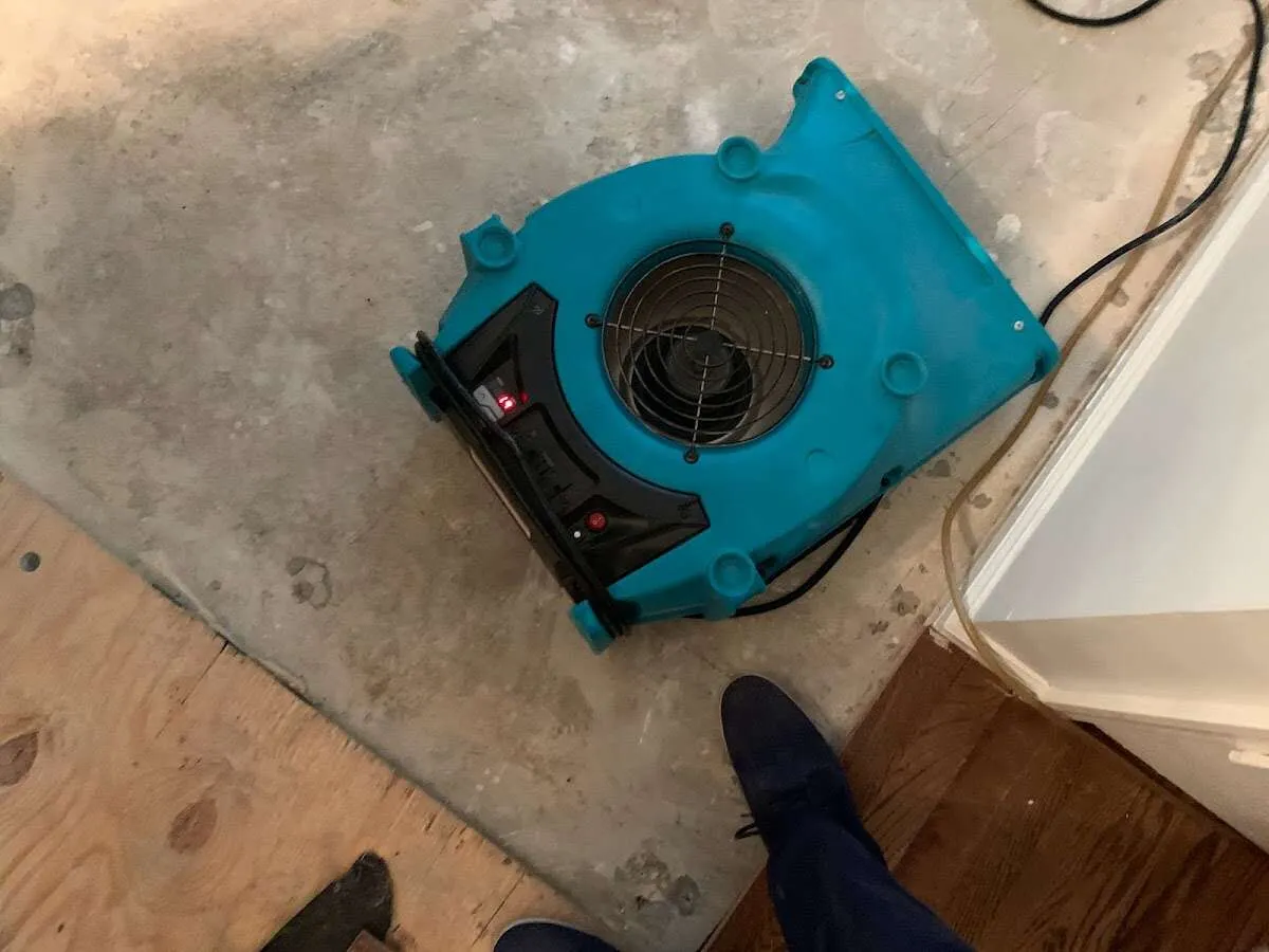Air mover drying subfloor during Commercial Water Damage Restoration in Liberty Hill